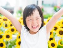 smiling girl in front of sunflowers