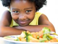 girl looking at plate of vegetables