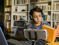 boy studying with a book and headphones