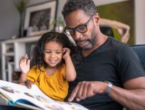 father and daughter looking at a book