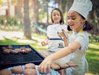 two children cooking on a barbecue