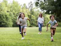 brother and sister running in a field