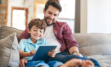 father and son looking at tablet