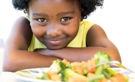 girl looking at plate of vegetables