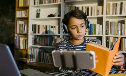 boy studying with a book and headphones