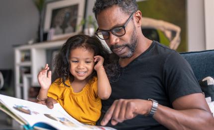 father and daughter looking at a book