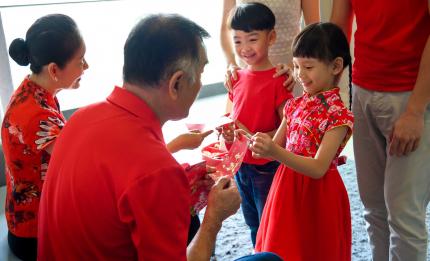 children receiving red envelopes from grandparents