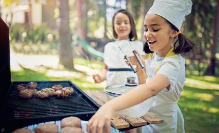 two children cooking on a barbecue