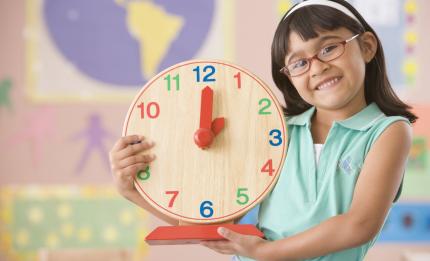 girl holding a clock