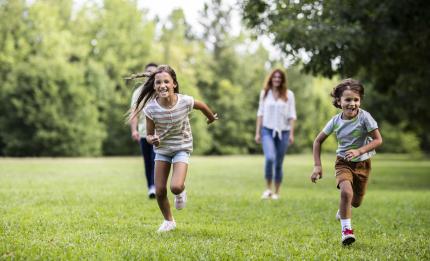 brother and sister running in a field