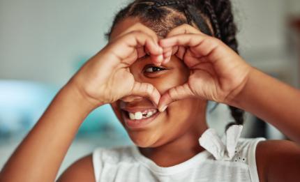 girl making a heart sign