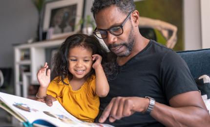 father and daughter reading a book