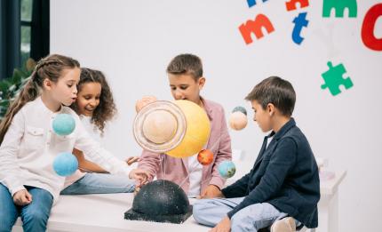 children looking at solar system model