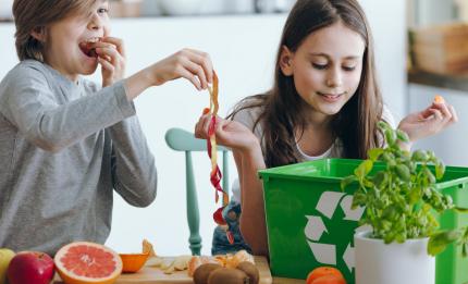 children putting food scraps in compost box