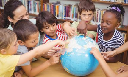 children looking at globe