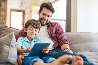 father and son looking at tablet