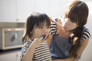 mother and child brushing their teeth