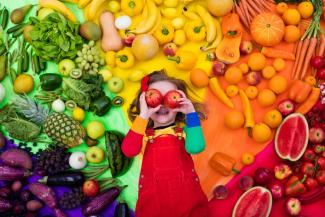 girl with different colour fruits and vegetables