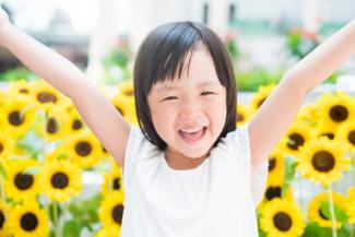 smiling girl in front of sunflowers