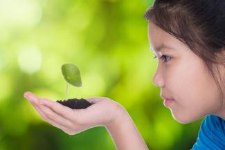 girl looking at a plant