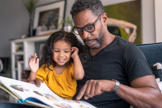 father and daughter looking at a book