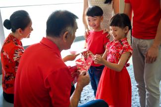 children receiving red envelopes from grandparents