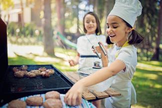 two children cooking on a barbecue