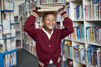 child with books on their head