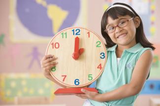 girl holding a clock