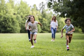 brother and sister running in a field