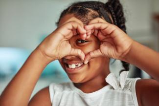 girl making a heart sign