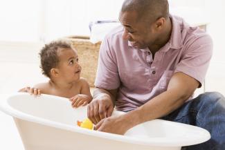 father and toddler at bathtime