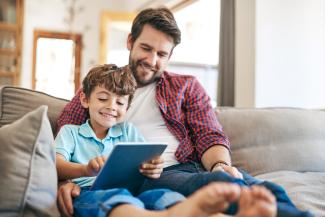 father and son looking at a tablet