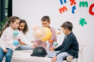 children looking at solar system model