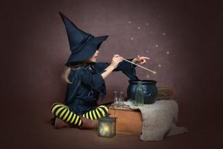 girl dressed as a witch making a spell