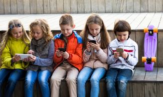 children using their phones and tablet