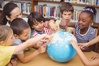 children looking at globe